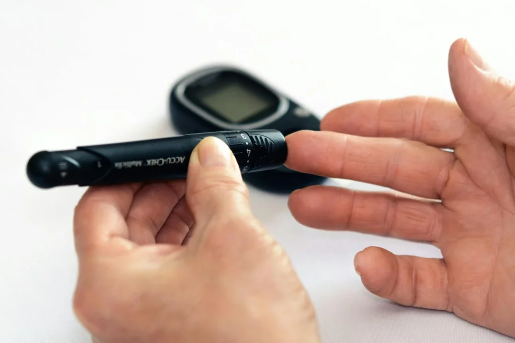 Close-up of a glucose check using an Accu-Chek lancing device to verify stable blood sugar levels (euglycemia) before, during, and after a run for people over 40 with Type-2 diabetes